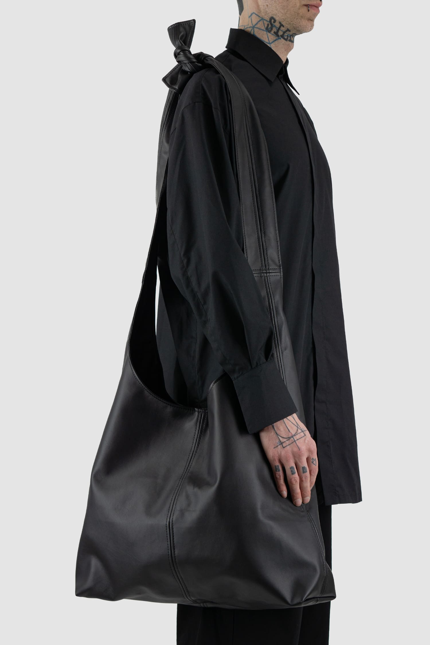 UY Studio - right side view of black Knotti XL vegan leather bag with tie-around straps design, press button closure, Permanent Collection.