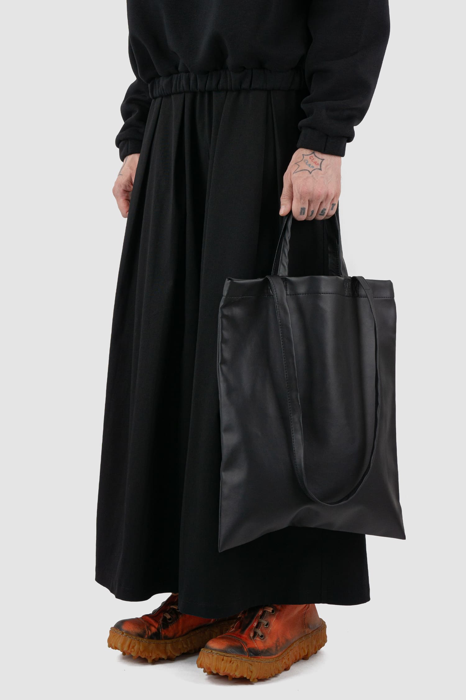 UY Studio - front low view of black vegan leather shopper tote bag from the FW24 collection with two different straps, an inside pocket for purses and cotton lining.