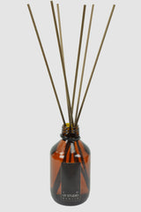 UY Studio - Front view of Signature Room Diffuser U in 200ml amber glass flacon with 8 rattan earth-toned sticks, Permanent Collection.