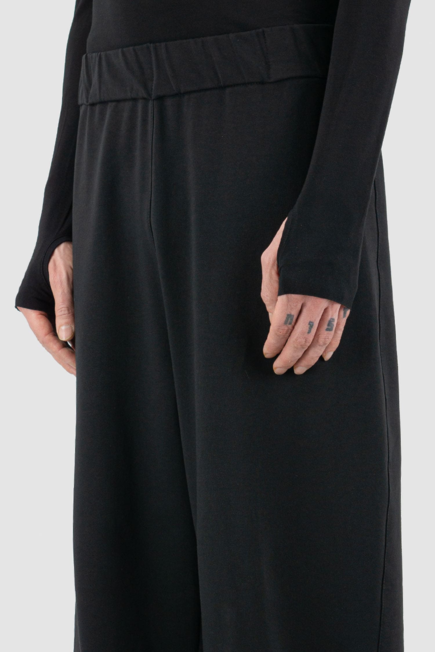UY Studio - waist detail view of black cotton wide leg Gangster sweatpants with elastic waistband, clean edge hem, Permanent Collection.