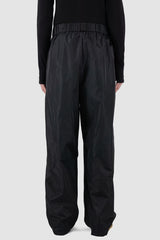 UY Studio - back view of black nylon wide fisher pants with elastic waistband, loose fit.