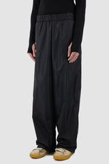 UY Studio - side view of black nylon wide fisher pants.