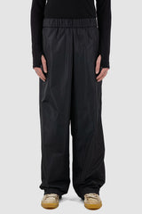 UY Studio - Front view of black nylon wide pants with elastic waistband, loose fit.UY Studio - Front view of black nylon wide fisher pants with elastic waistband, loose fit.