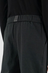 UY Studio - waist view of black Less pants with carrot cut, elastic waist, made from cotton twill, Permanent Collection.