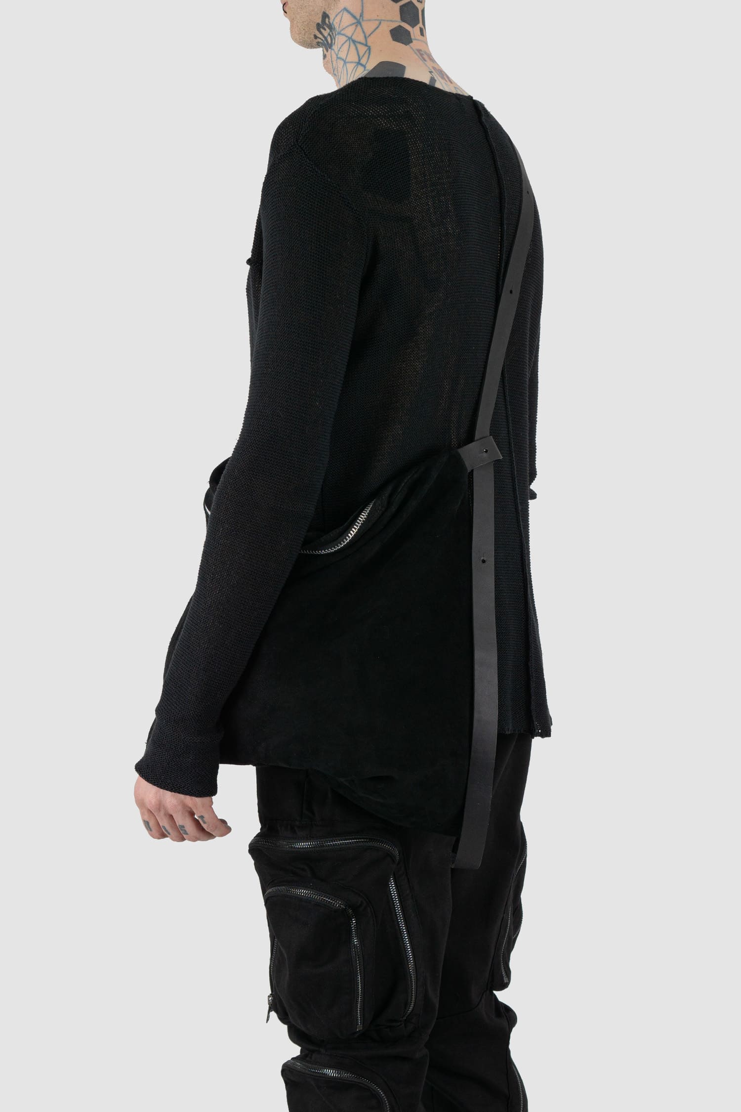 Werkschwarz - Model back view of black waxed reversed leather one-shoulder pack bag is the ideal piece to wear crossbody from the Permanent collection. It features a waxed finish, an origami shape, and a heavy-duty YKK zipper, combining functionality with contemporary design.