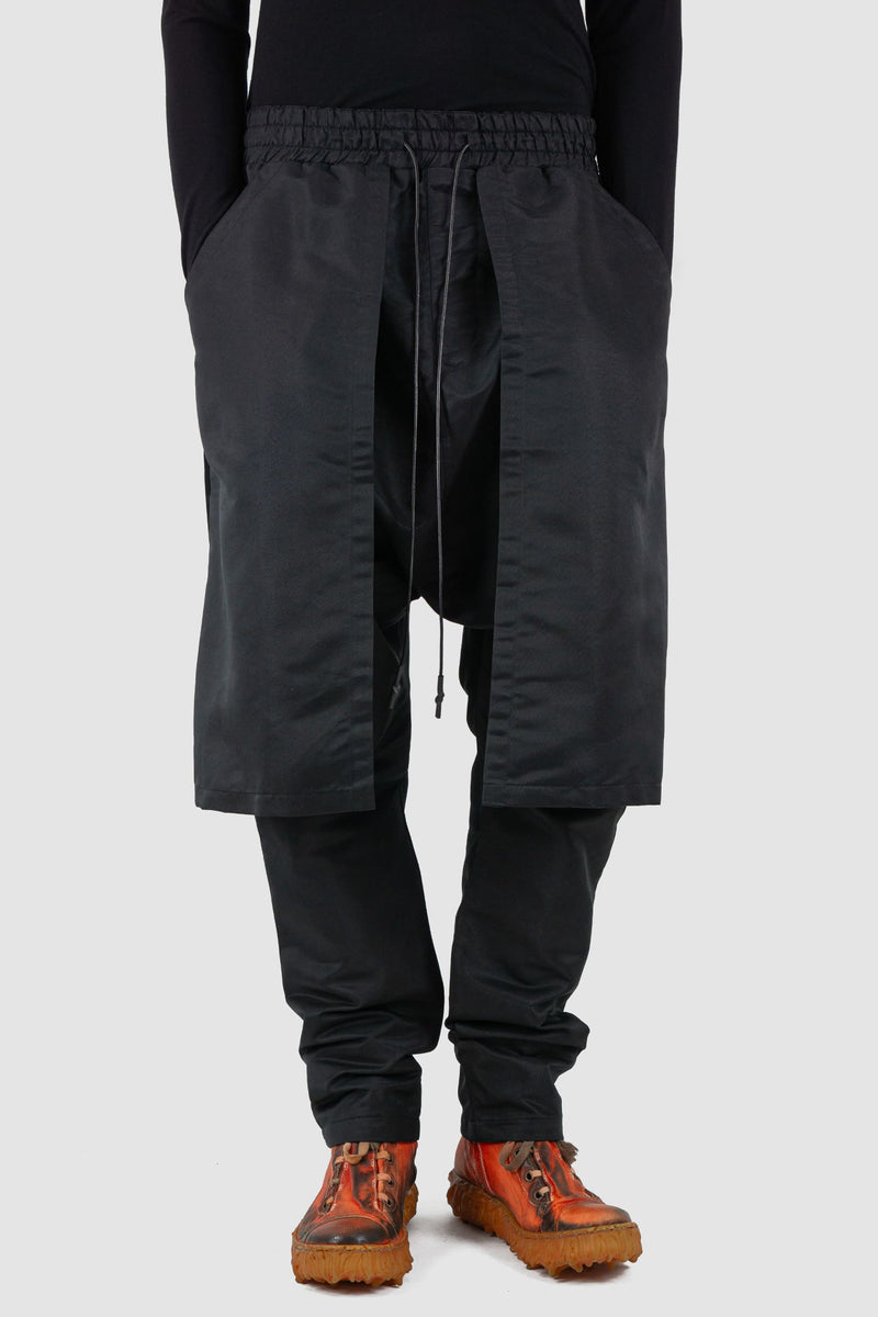 XConcept - Front legere view of black front panel trousers for men with decorative inserts on both sides, elasticated waistband with drawstring, FW24 Collection.