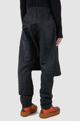 XConcept - Back side view of black front panel trousers for men with decorative inserts on both sides, elasticated waistband with drawstring, FW24 Collection.