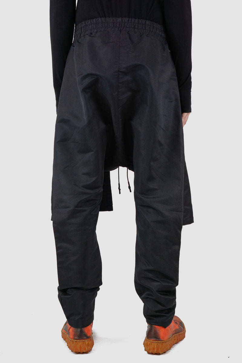 XConcept - back view of black front panel trousers for men with decorative inserts on both sides, elasticated waistband with drawstring, FW24 Collection.