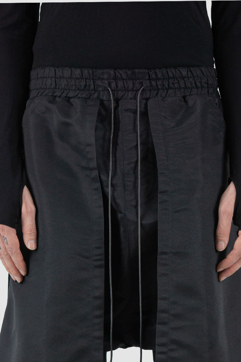 XConcept - waist view of black front panel trousers for men with decorative inserts on both sides, elasticated waistband with drawstring, FW24 Collection.