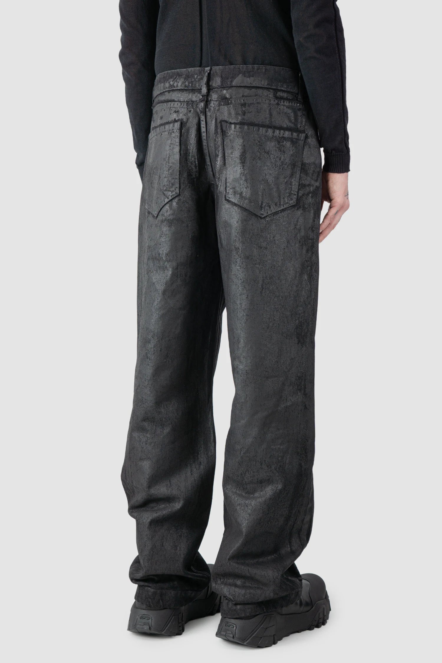 La Haine Inside Us - model back side view of men’s Black Hand-Painted Rubberized Coated Denim Jeans