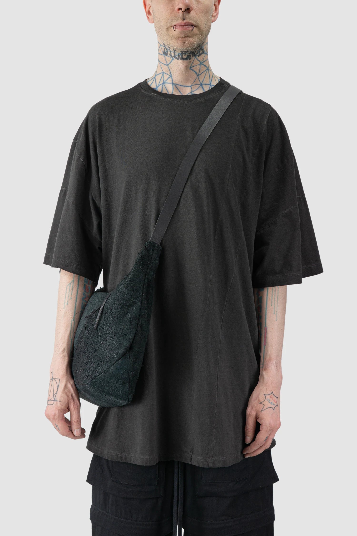 Werkschwarz - model front view of men’s FW25 Black Raw Leather Shoulder Bag Textured Werk 42G